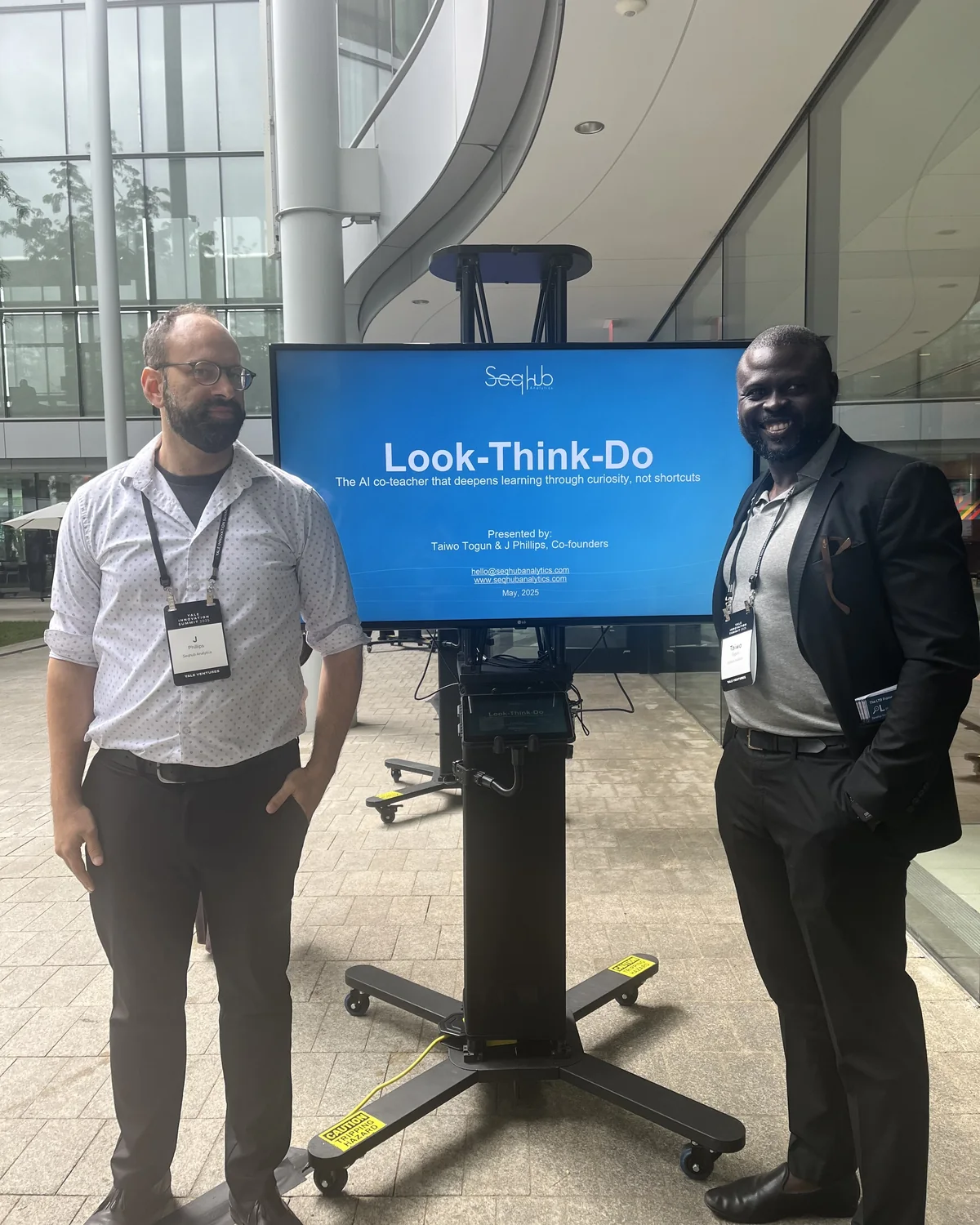 Taiwo Togun and J Phillips beside a Look-Think-Do display